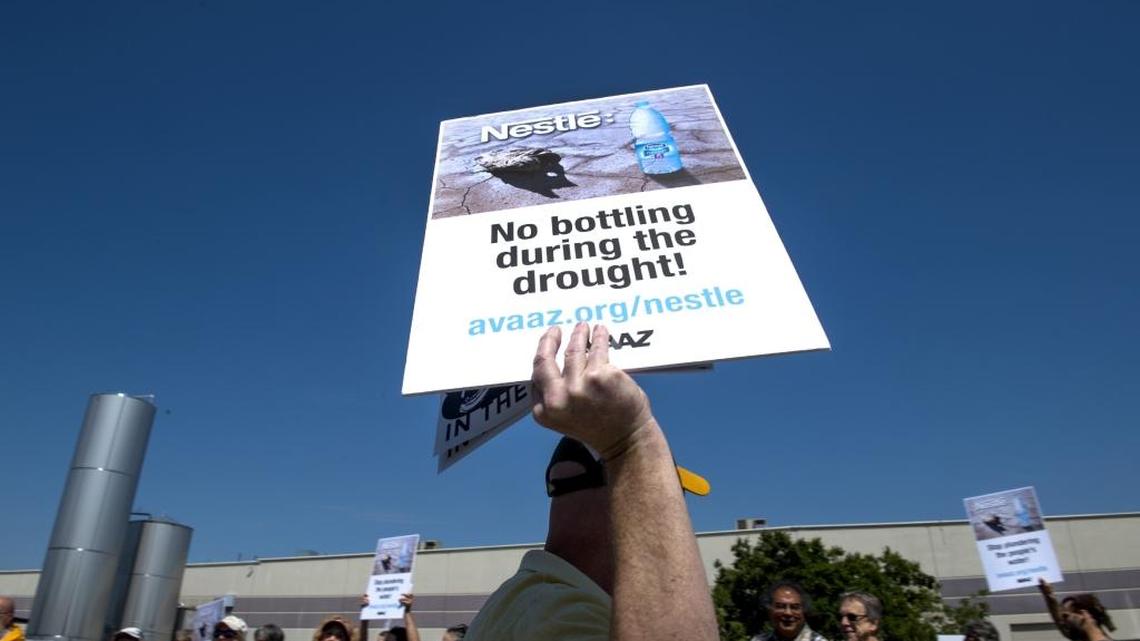 A protester holds up a sign during a 2015 rally outside the Nestle Waters bottling plant in Sacramento. An advocacy groups says the company deserves credit for pledging to use recycled plastic in its bottles.