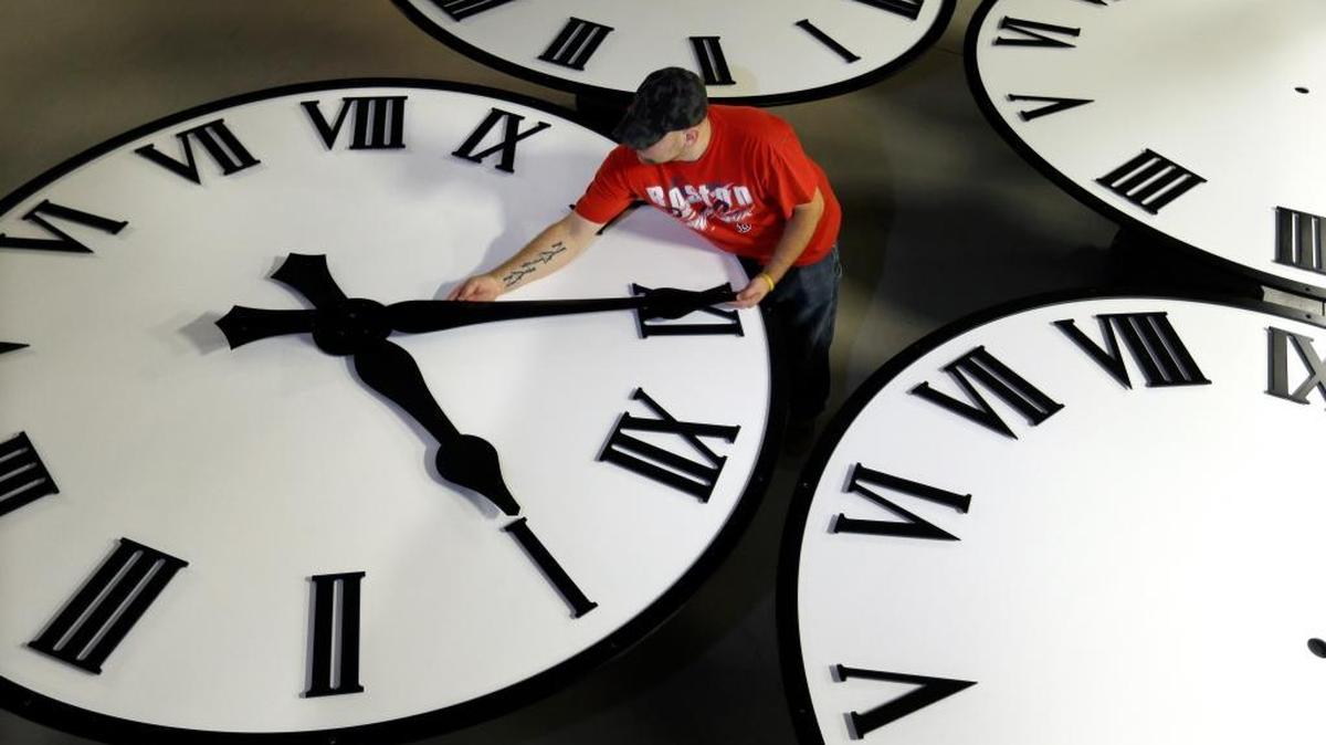 In this Thursday, Nov. 3, 2016 photo, Dan LaMoore sizes hands for an 8-foot diameter silhouette clock at Electric Time Co., in Medfield, Mass. Daylight saving time ends at 2 a.m. local time Sunday, when clocks are set back one hour. (AP Photo/Elise Amendola)