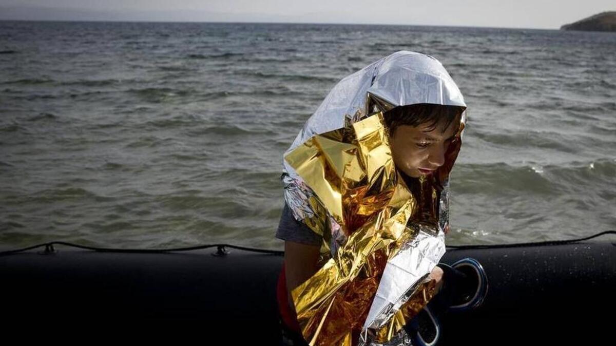 A Syrian boy wrapped in a thermal blanket arrives at the island of Lesbos, Greece, in September after a dangerous sea crossing.