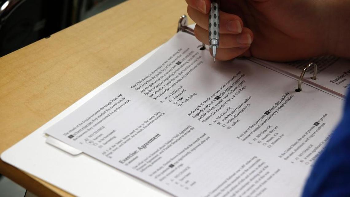 A student looks at questions during a college test preparation class at Holton Arms School in Maryland. The companies behind the SAT and ACT are competing for market share.