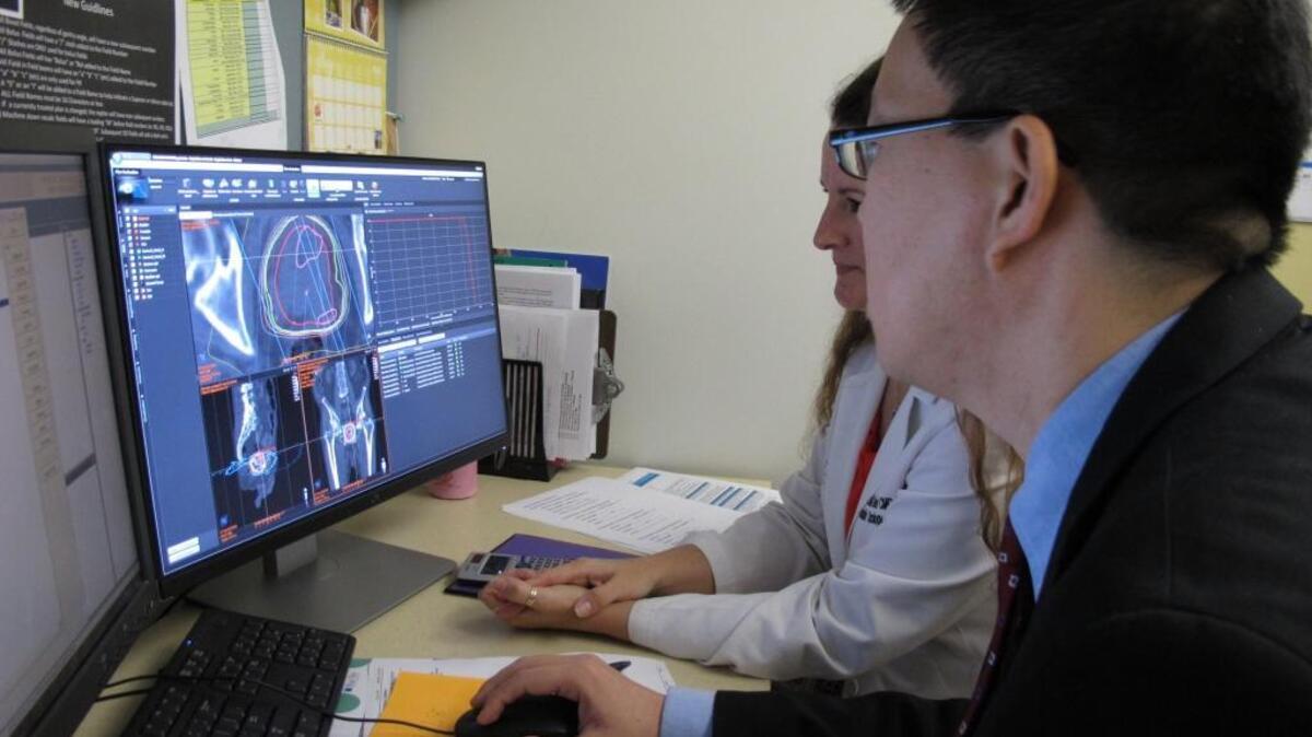 Ronald C. Chen consults with colleague Misty Lehman-Davis on a patient’s scans at the UNC Lineberger Comprehensive Cancer Center in 2016. Chen is the lead author on a new study of aggressive cancer treatment in the last month of a patient’s life.