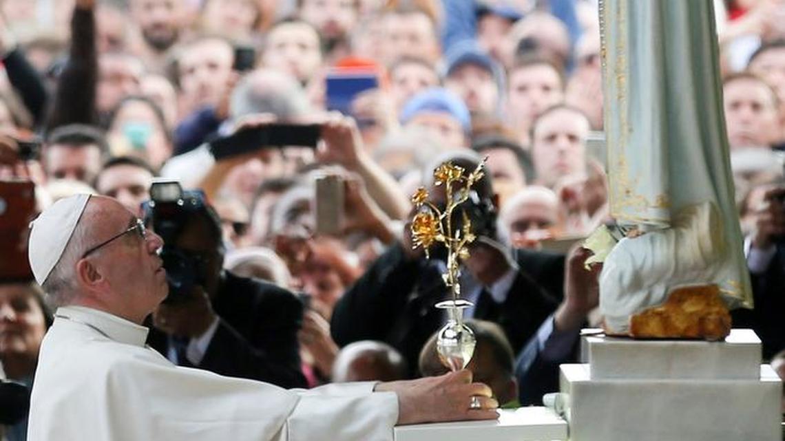 Pope Francis makes an offering in May at the Sanctuary of Our Lady of Fatima in Fatima, Portugal. The massive gathering in expectation of a miracle after three children reported seeing the Virgin Mary happened 100 years ago Oct. 13. (Jose Sena Goulad/Pool Photo via AP)