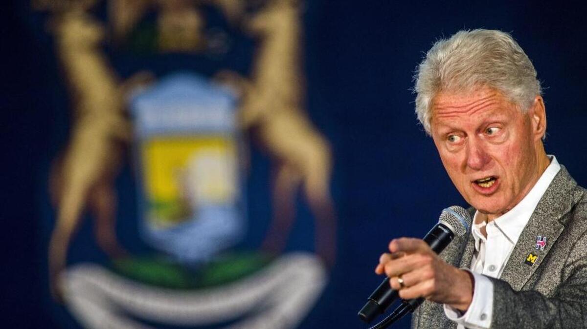 Former President Bill Clinton speaks Monday at a campaign event in Flint, Mich. He called Obamacare a “crazy system,” and later tried to clarify his remarks.