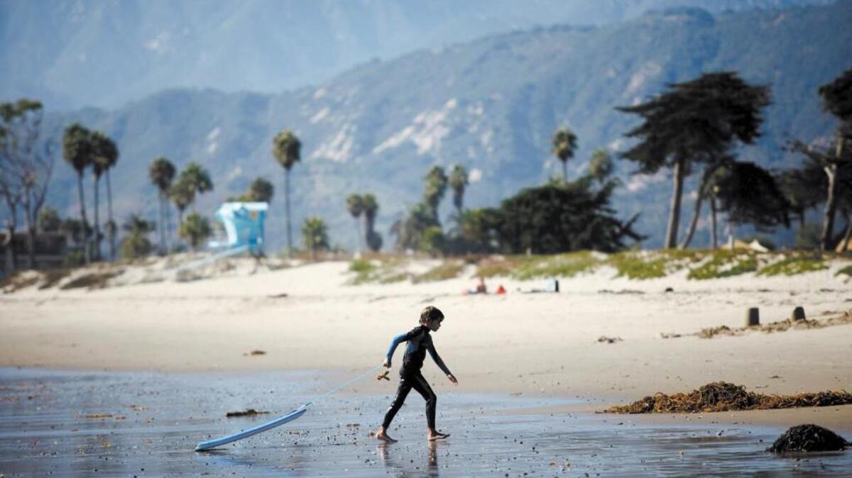 A boy pulls a boogie board across the beach in Carpinteria, the small city in Santa Barbara County that helped start the wave of banning plastic bags.