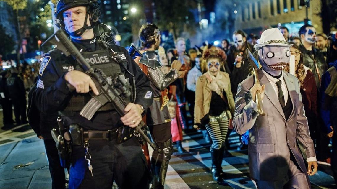 Heavily armed police guard as revelers march during the Greenwich Village Halloween Parade on Tuesday night, hours after a truck attack killed eight people on a busy city bike path in what authorities called an act of terror.