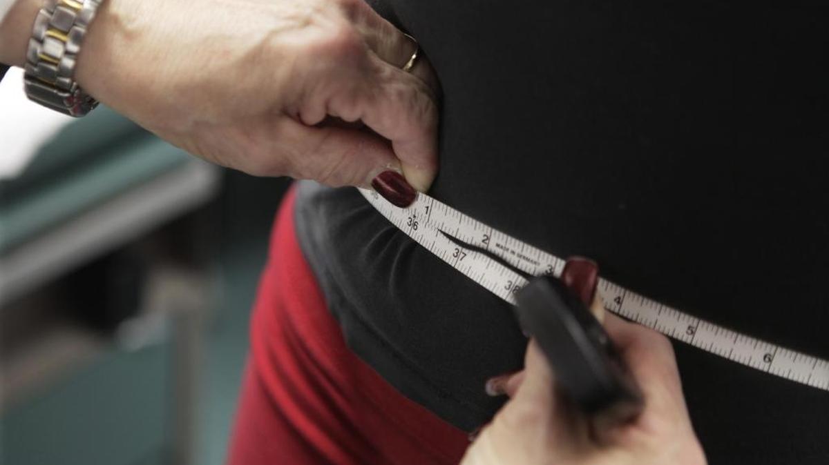 A waist is measured during an obesity-prevention study. A new study suggests that factors such as diet and exercise are connected with the health disparity between the rich and poor.