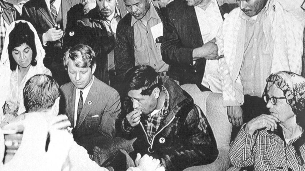 Cesar Chavez eats a piece of bread to end his 25-day fast while Sen. Robert F. Kennedy looks on in Delano in a 1968 photo from files. About 4,000 farm workers joined Chavez in a symbolic bread-breaking ceremony marking the end of the leader's fasting for non-violence.