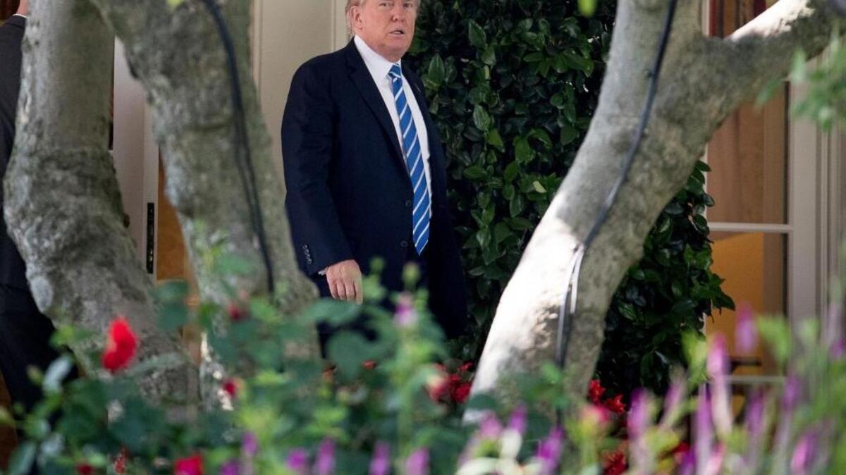 President Donald Trump walks out of the Oval Office on Monday to view the solar eclipse.
