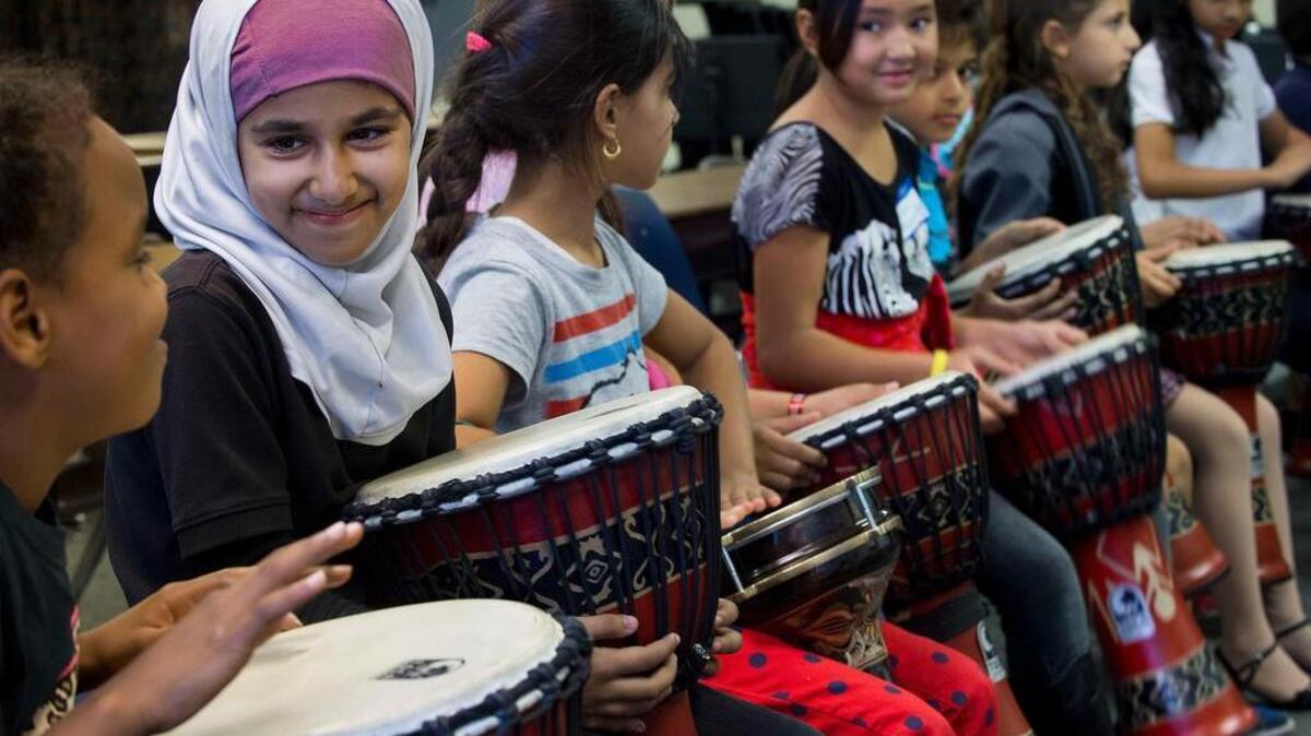 Students prepare to play drums at an after-school music program for refugee students at Howe Avenue Elementary School in Sacramento.