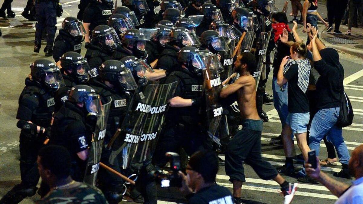 Charlotte-Mecklenburg police officers begin to move protesters down a downtown street Wednesday night as they to quell public anger over a fatal police shooting of a black resident.