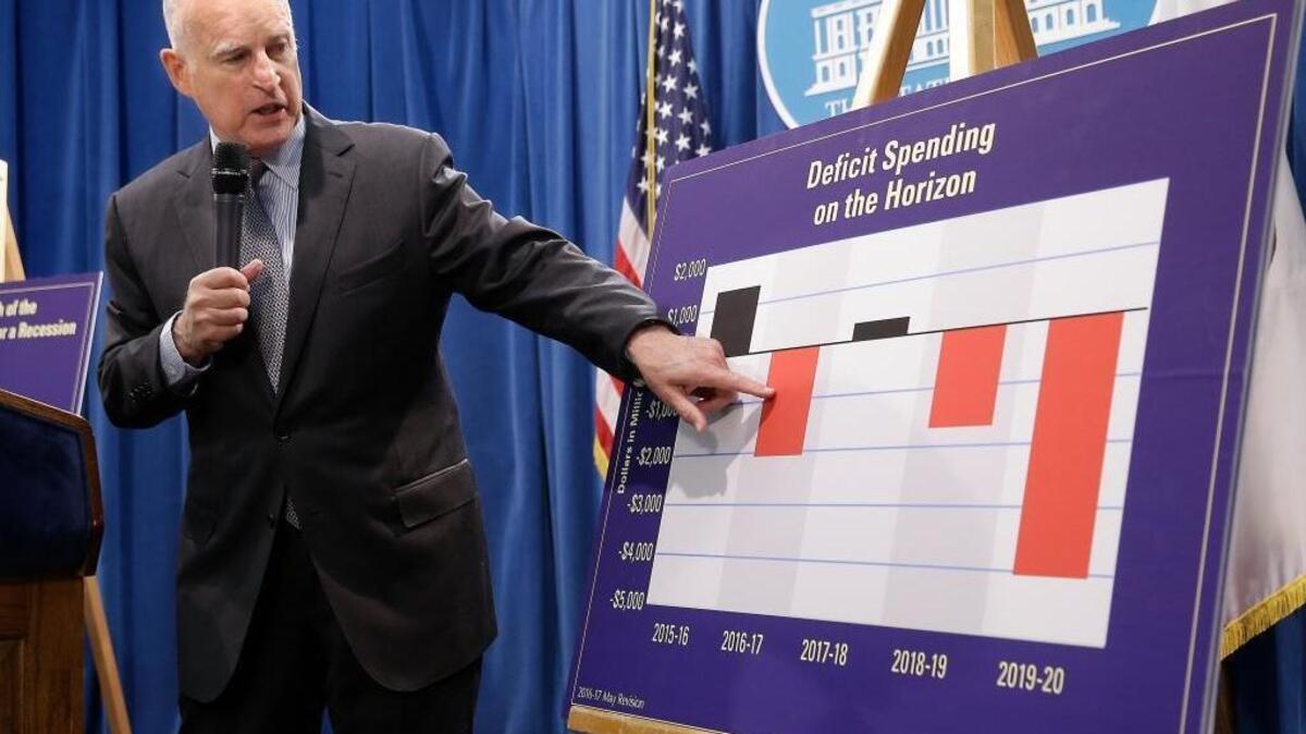 Gov. Jerry Brown shows a chart indicating possible future deficit spending as he discusses his revised 2016-17 state budget plan released last month. Brown proposed a $122.2 billion spending plan for California, down slightly from his January proposal as tax revenues are expected to fall below expectations.
