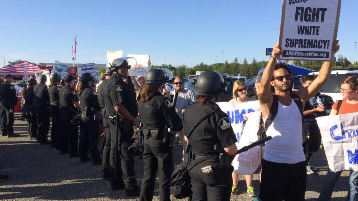 Police separate several dozen protesters from thousands of Donald Trump supporters at a Trump campaign rally in Sacramento.