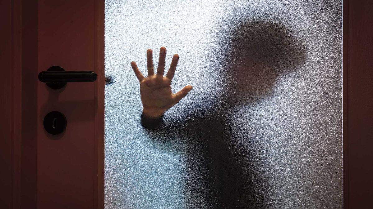 Stock image of child obscured by frosted glass.
