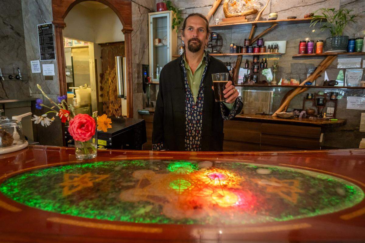 Colter Merrick, owner of Elixart, holds a non-alcoholic drink inside his mocktail bar and lounge in Nevada City on Thursday, May 28, 2026. Merrick has been in business for 15 years and says his bar offers health and wellness through plant-based ingredients that he says support longevity, detoxification, immunity and overall well-being.