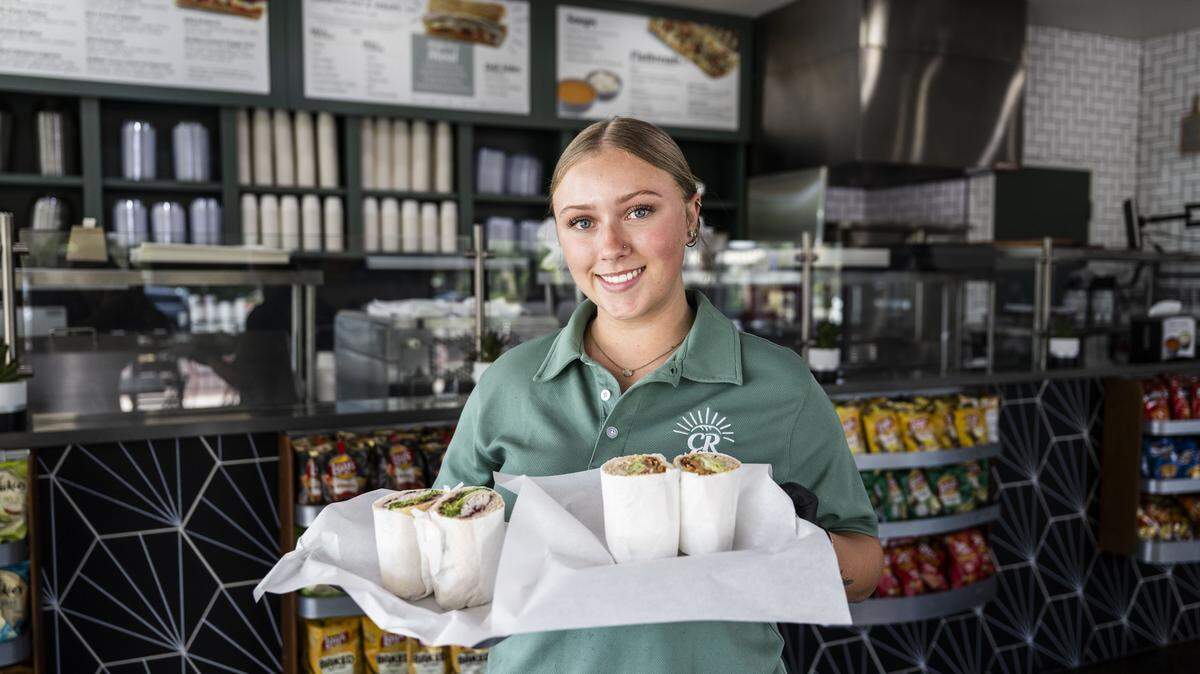 Jordyn Garcia, a Cali Rays Sourdough Deli employee, holds a cranberry turkey and a hot crunch chicken sandwich at the deli's newest location in Galt on Tuesday, May 26, 2026.