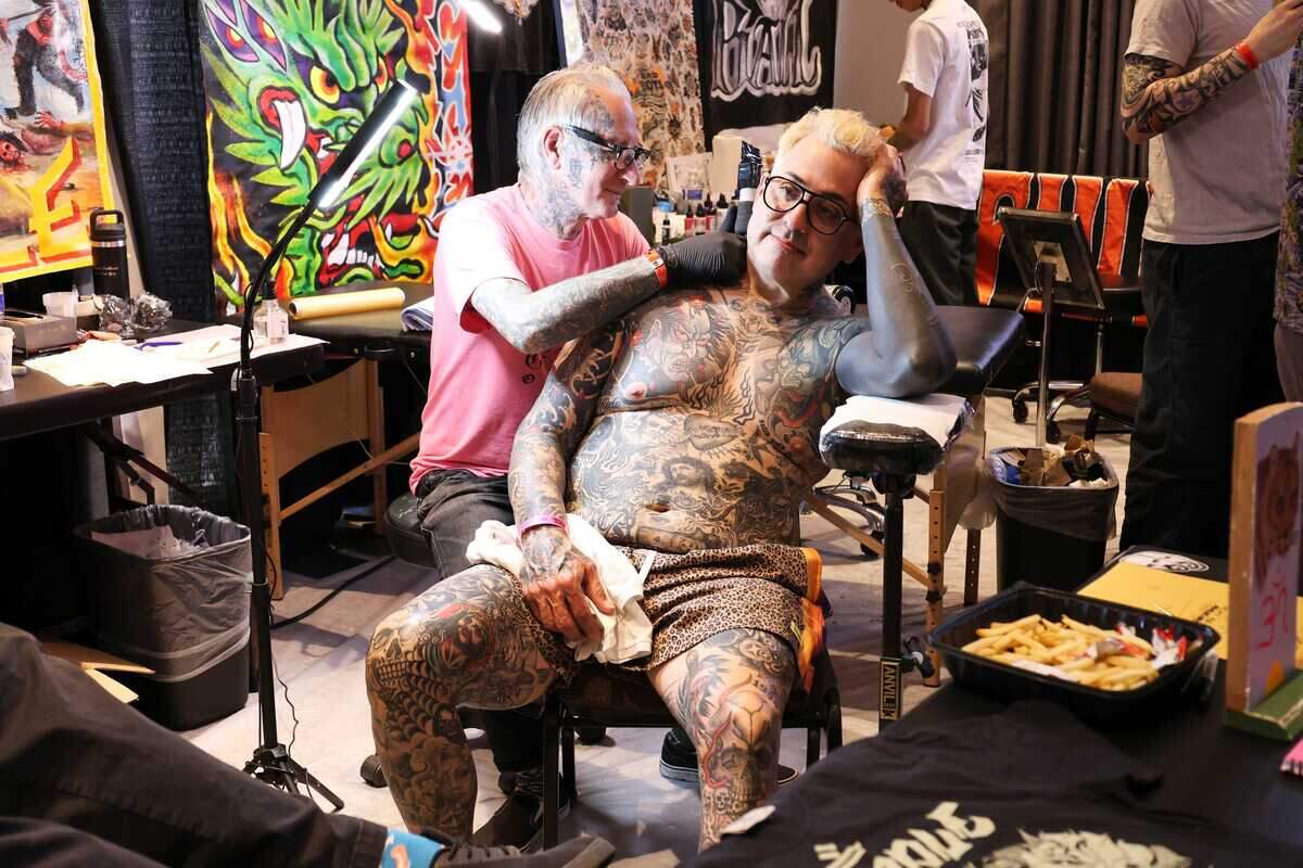 Isaac Silva receives a neck tattoo from tattoo artist Freddy Corbin at the Capitol City Classic tattoo convention in Sacramento, California, on Saturday, June 12, 2026.
