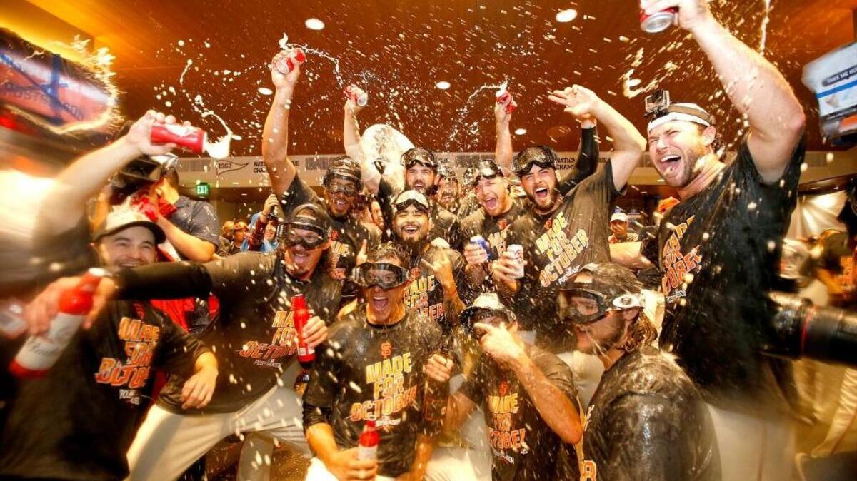 The Giants celebrate in the clubhouse after clinching the second National League wild-card spot with their 7-1 win over the Los Angeles Dodgers in San Francisco on Sunday, Oct. 2, 2016.