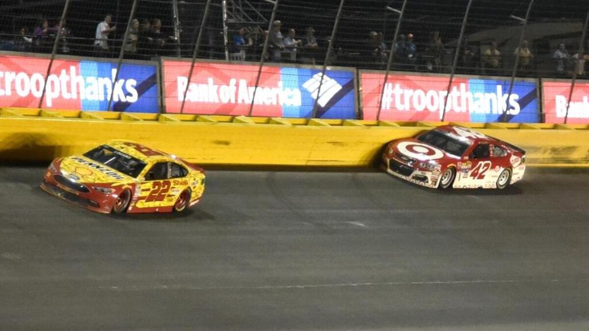 Joey Logano drives past Kyle Larson, who hits the wall in Turn 2 during the closing laps of the NASCAR All-Star auto race at Charlotte Motor Speedway in Concord, N.C., on Saturday, May 21, 2016. Logano won the race.