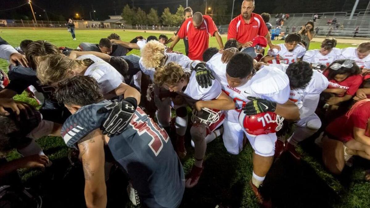 Players from Mira Loma and San Juan kneel in prayer following their game Friday, Sept. 16, 2016, at San Juan High School. The visiting Matadors beat the Spartans 49-6.