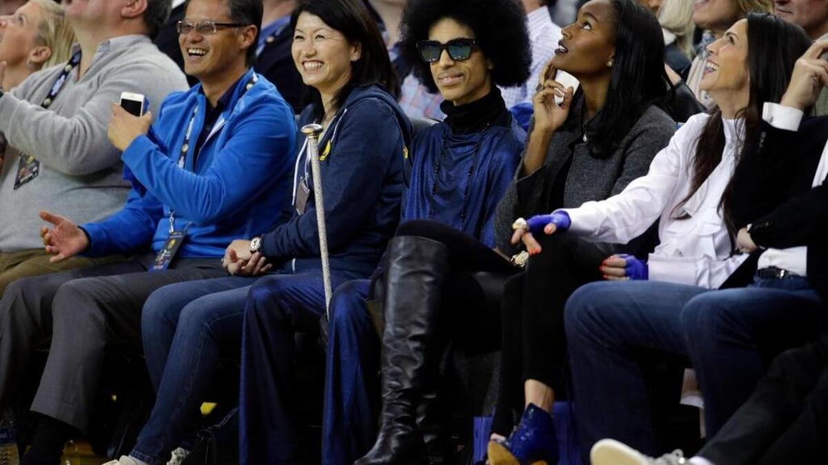 Singer Prince, center, smiles as he watches the Warriors play the Oklahoma City Thunder on Thursday, March 3, 2016, at Oracle Arena in Oakland.