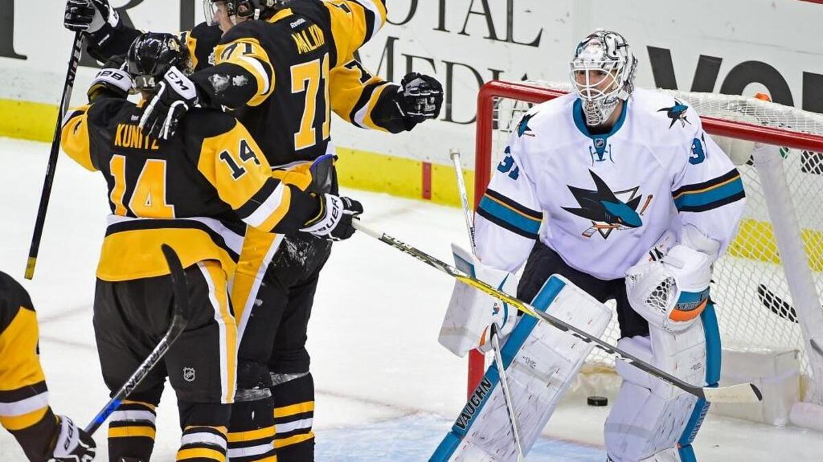 Pittsburgh Penguins left wing Chris Kunitz (14), center Evgeni Malkin (71) and right wing Patric Hornqvist celebrate the winning goal in front of San Jose Sharks goalie Martin Jones during the third period of an NHL hockey game Thursday, Oct. 20, 2016, in Pittsburgh. The Penguins defeated the Sharks 3-2.