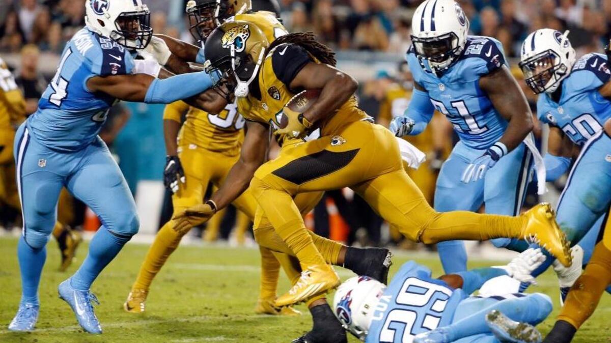 Jacksonville Jaguars running back Denard Robinson (16) is tripped by Tennessee Titans cornerback Perrish Cox (29) during an NFL football game Thursday, Nov. 19, 2015, in Jacksonville, Fla. The teams were outfitted in the NFL’s Color Rush uniforms. The Jaguars and Titans combined for two touchdowns and seven field goals. So much for the rush.