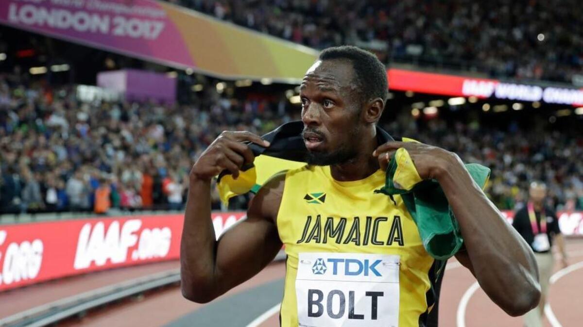 Jamaica’s Usain Bolt holds his national flag after placing third in the men’s 100m final during the World Athletics Championships in London Saturday, Aug. 5, 2017.