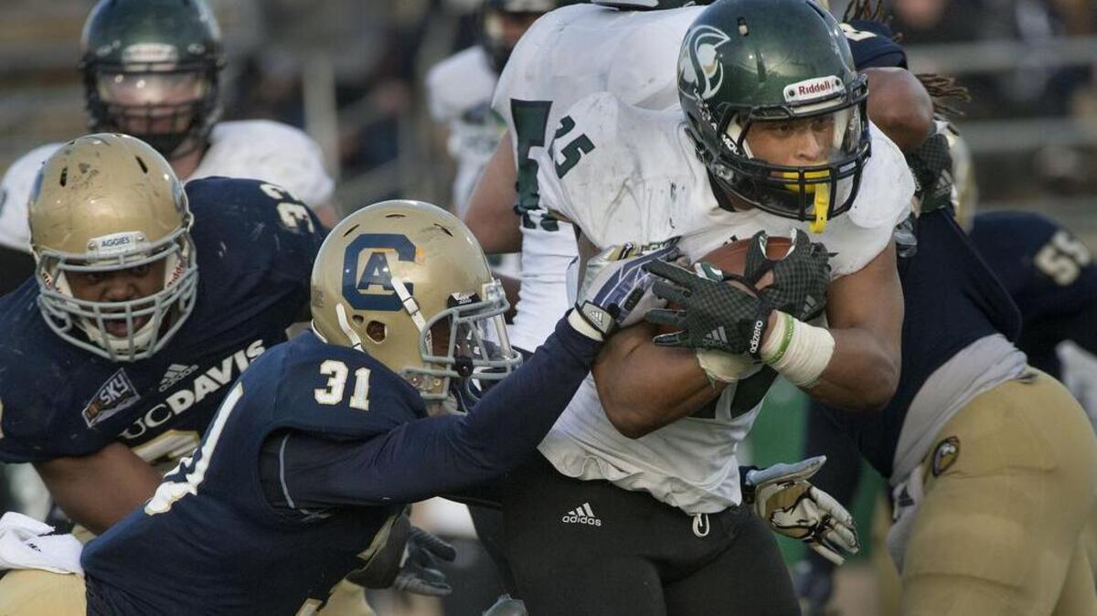 Hornets running back Jordan Robinson (25) breaks a tackle by Aggies cornerback Nate Walker (31) during the 2014 Causeway Classic between Sacramento State and UC Davis. This season they have combined for a 3-15 record. They will meet Nov. 21, 2015 at Sacramento State.