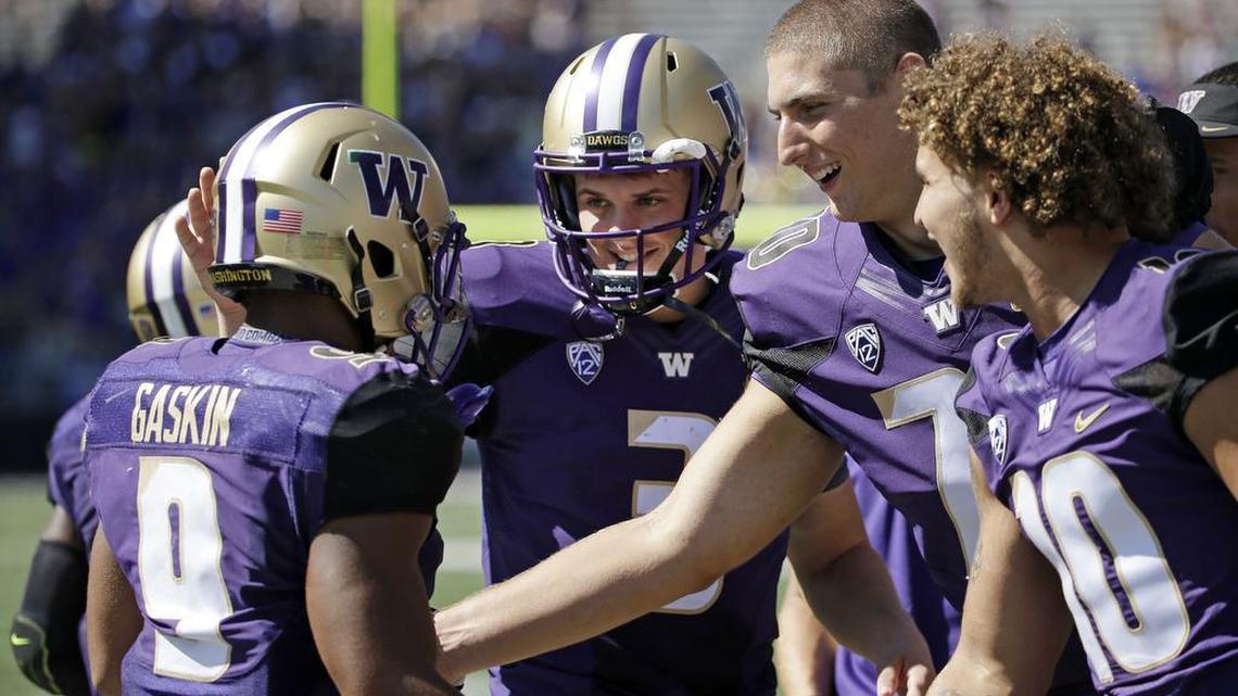 
Washington’s Myles Gaskin (9) is congratulated on the last of his three touchdowns against Sacramento State by quarterback Jake Browning (3), Jared Hilbers (70) and Tony Rodriguez (10) in the second half of an NCAA college football game Saturday, Sept. 12, 2015, in Seattle. Washington won 49-0. (AP Photo/Elaine Thompson) 

