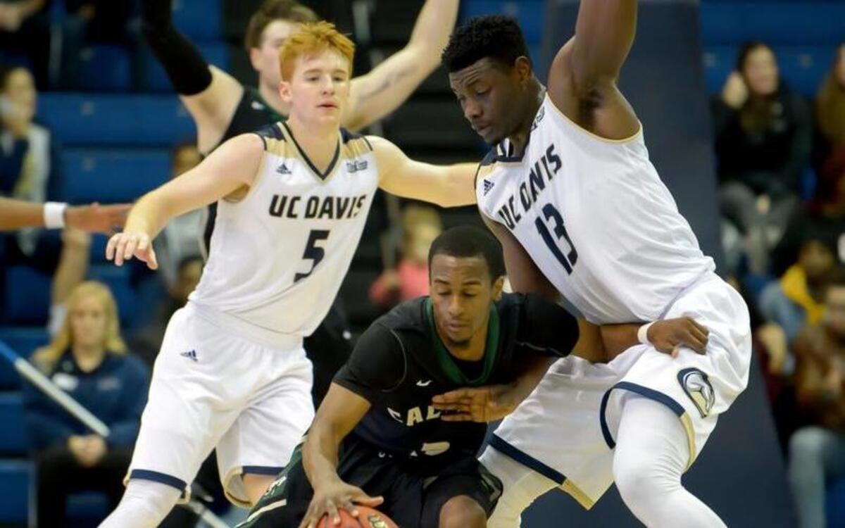 UC Davis Aggies Siler Schneider (5) and J.T. Adenrele (13), defend Cal Poly Mustangs Donovan Fields on Jan. 7.