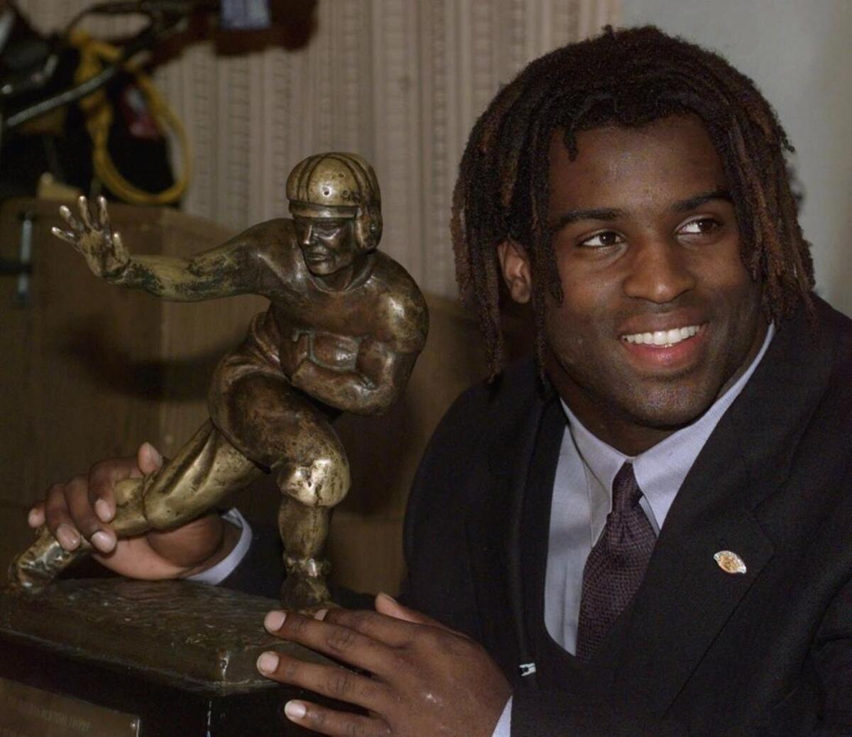 Former-Texas tailback Ricky Williams smiles as he holds a copy of the Heisman Trophy on Saturday, Dec. 12, 1998, at the Downtown Athletic Club in New York.