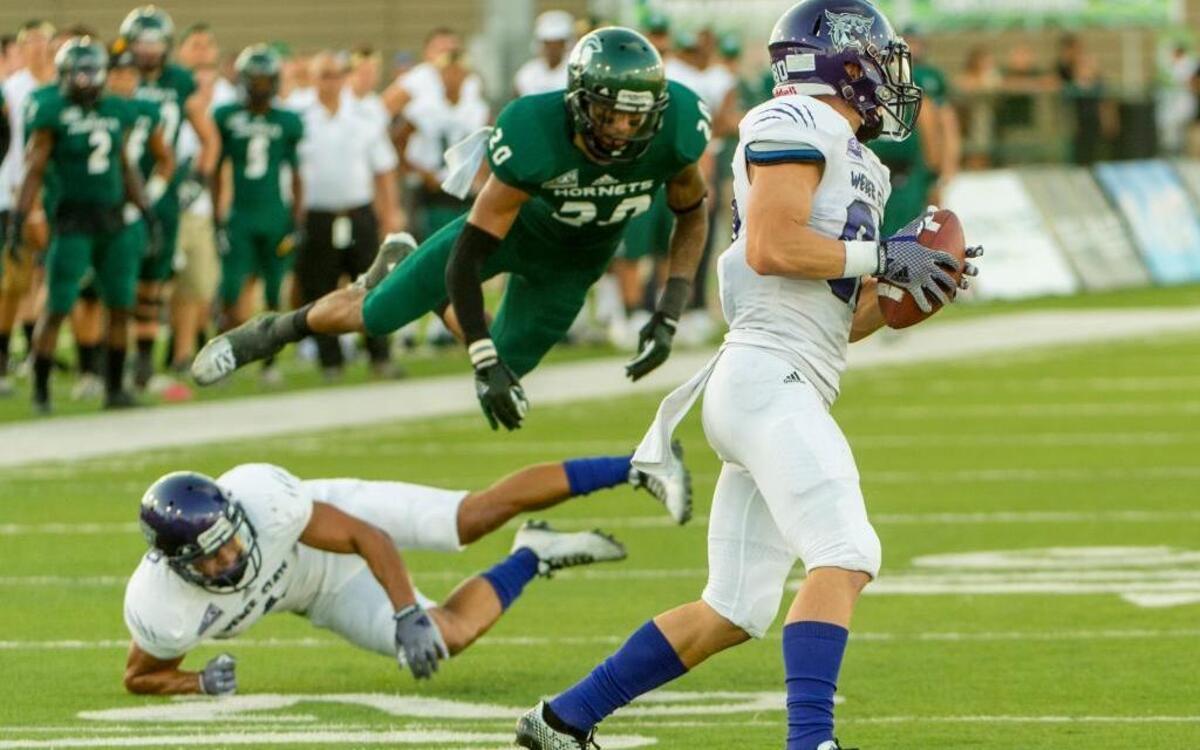
Weber State Wildcats football player, Drew Batchelor (80), runs with the ball as Sacramento State Hornets football player, Nicholas Payne (20), is upended during the first quarter as the Sacramento State Hornets host the Weber State Wildcats at Hornet Stadium, Saturday September 13, 2014. 
