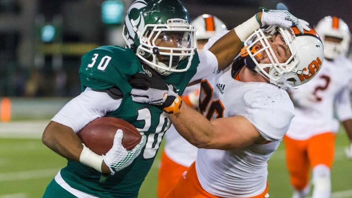 Sacramento State running back Mister Harriel, left, stiff-arms Idaho State linebacker Hayden Stout during the fourth quarter on Oct. 24.