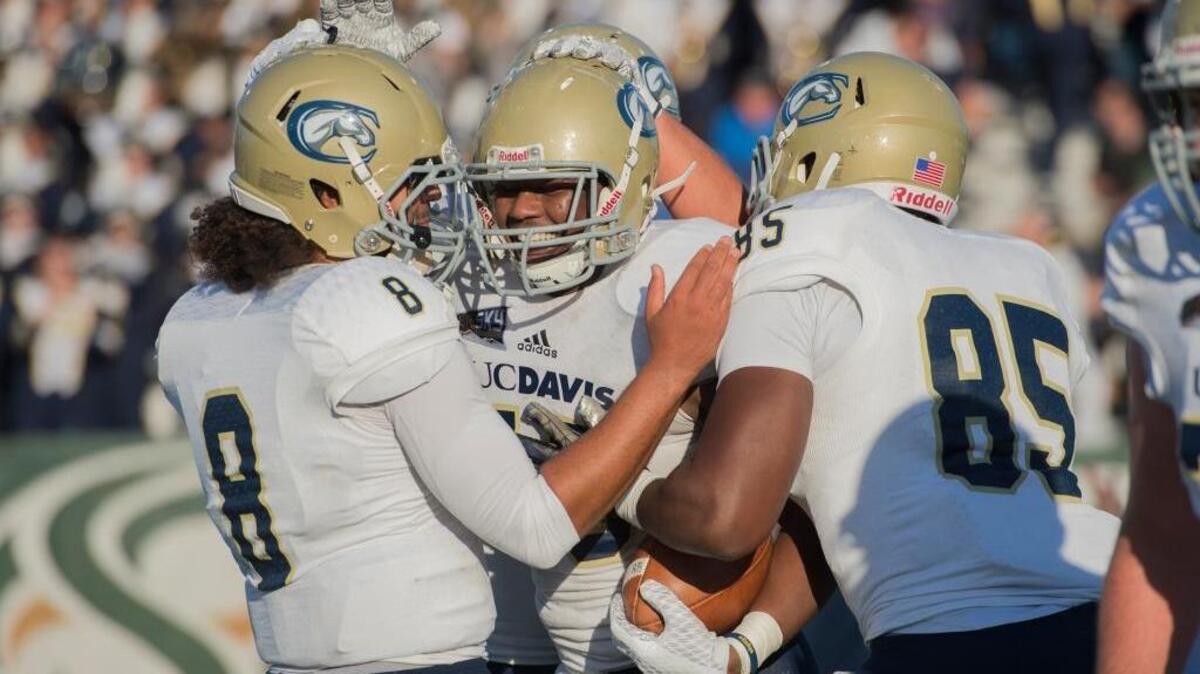 Zach Jones, center, is congratulated by UC Davis teammates, quarterback Keleen Culbertson, left, and Nehemiah Winston after catching a touchdown pass in the second quarter on Saturday, Nov. 21, 2015 at Hornet Stadium in Sacramento. The Aggies won the Causeway Classic 35-21.