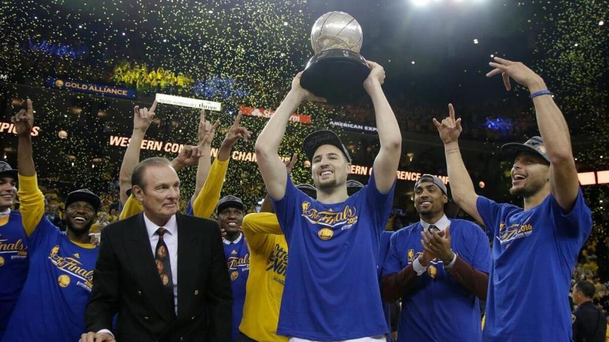 Former NBA player Rick Barry, center left, watches as Golden State Warriors guard Klay Thompson, center, Stephen Curry, right, and their teammates celebrate after beating the Oklahoma City Thunder in Game 7 of the NBA basketball Western Conference finals, Monday, May 30, 2016 in Oakland. The Warriors won 96-88.