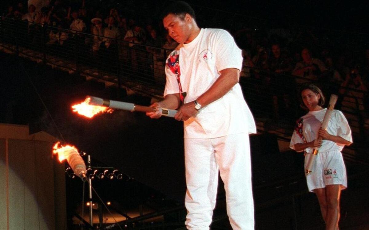 Muhammad Ali lights the Olympic torch during the 1996 Games as swimmer Janet Evans looks on, July 19, 1996 in Atlanta. Ali died Friday, June 3, 2016 at age 74. The former three-time heavyweight boxing world champion spent much of his life as a global humanitarian.