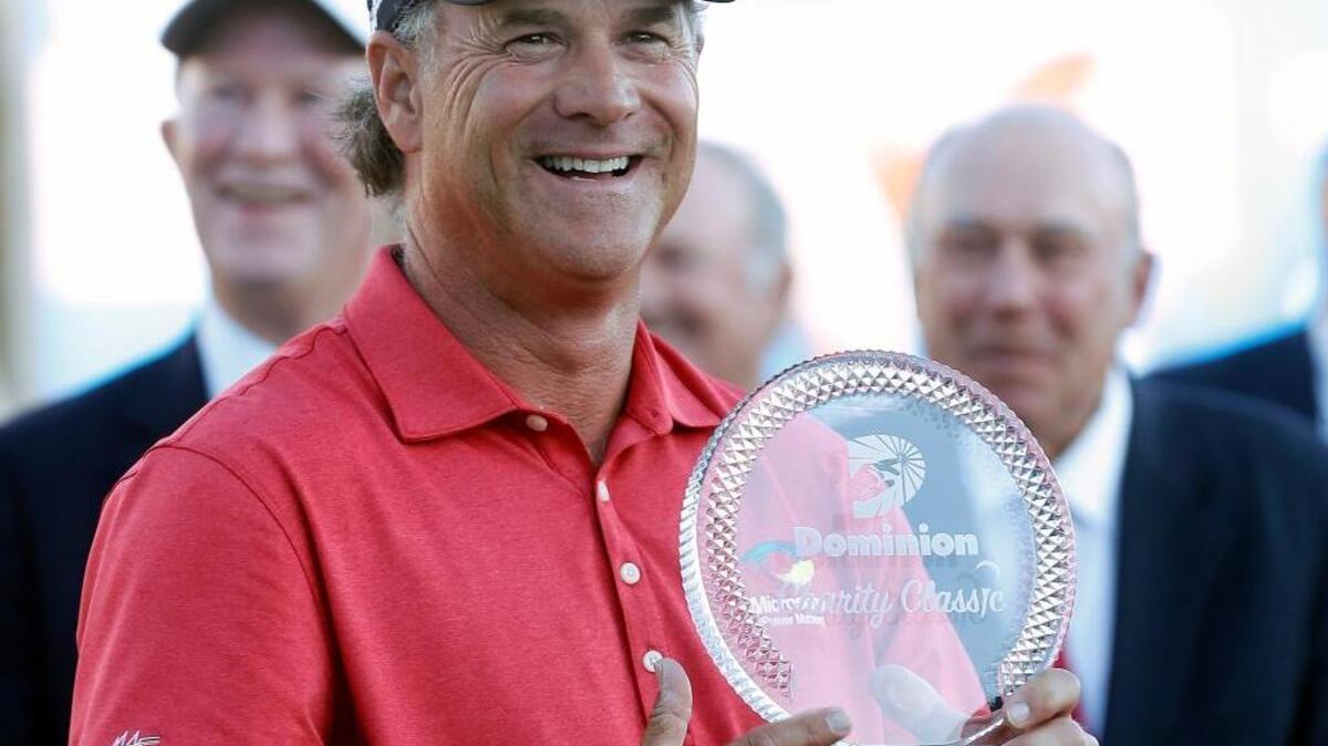 Scott McCarron holds the trophy after winning the Dominion Charity Classic golf tournament Sunday, Nov. 6, 2016, in Richmond, Va.