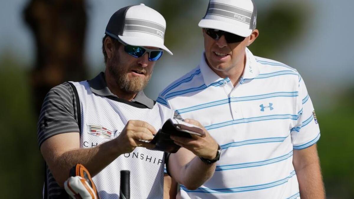 Sacramento’s John Wood, left, confers with Hunter Mahan during the first round of the Cadillac Championship golf tournament Friday, March 7, 2014, in Doral, Fla. Wood is now working as a caddie for Matt Kuchar.