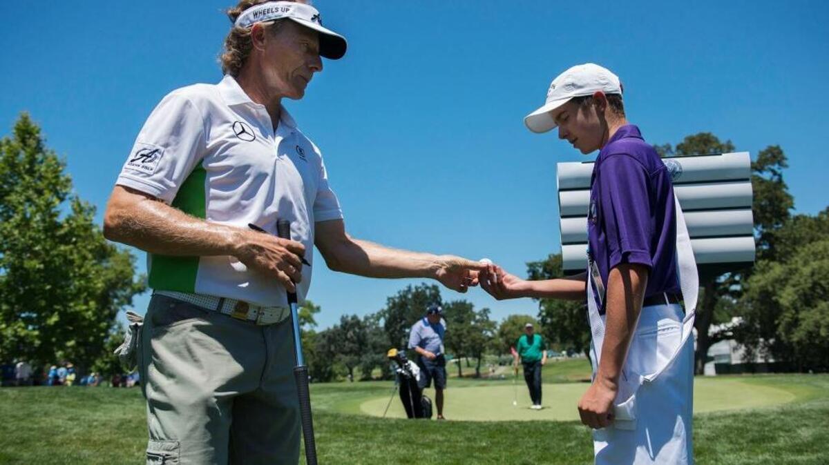 Sign bearer and volunteer Joe Fowler, right, gets a signed golf ball from Bernhard Langer during the 2015 U.S. Senior Open at Del Paso Country Club on Tuesday, June 23, 2015 in Sacramento.