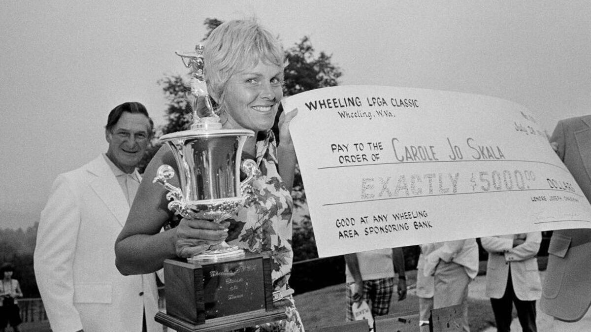 Carole Jo Skala smiles as she holds the trophy and check after winning the Wheeling Ladies Classic on July 28, 1974, in Wheeling, W.Va.