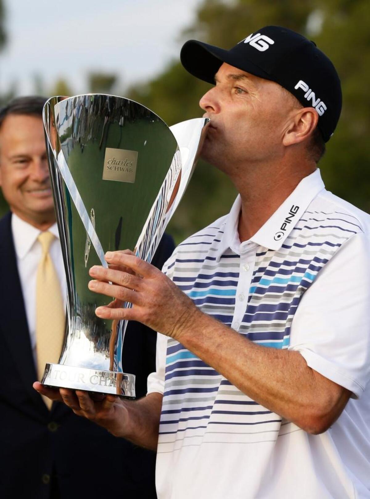 Kevin Sutherland kisses the trophy after winning the Charles Schwab Cup Championship on Sunday at Phoenix Country Club in Phoenix, Ariz. Sutherland finished 15-under-par, winning by one-stroke.