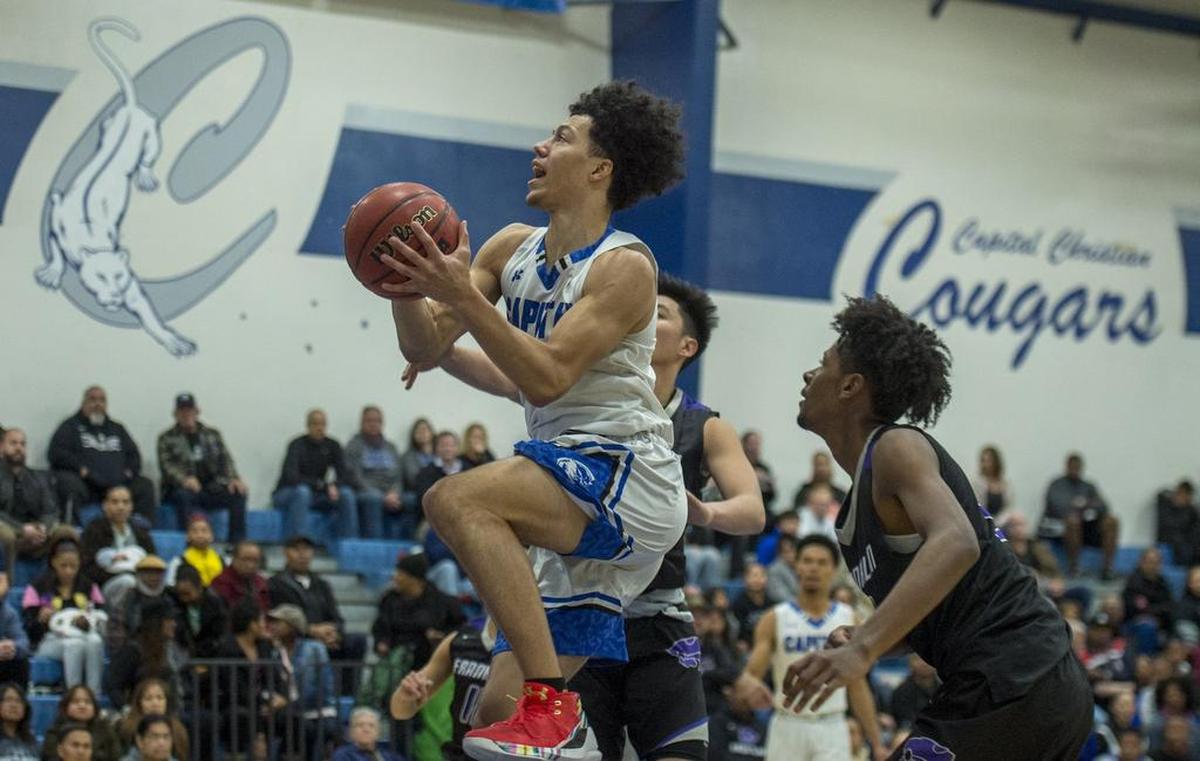 Capital Christian Cougars Rick Barros (1) lays a ball up for two points in the first half.