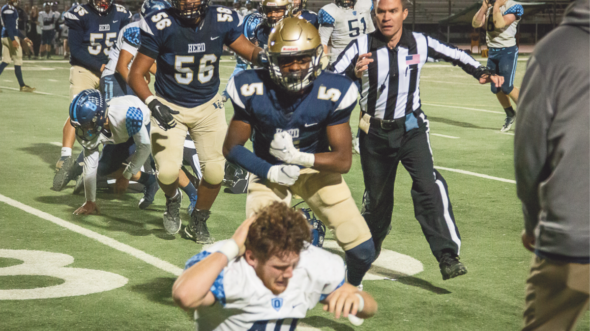 Elk Grove’s Tre’von Frazier reacts violently Friday to a play he and his teammates perceived as dirty when he yanked off the helmet of Oakmont defensive lineman Josh Wallentine and hit him in the back with it.