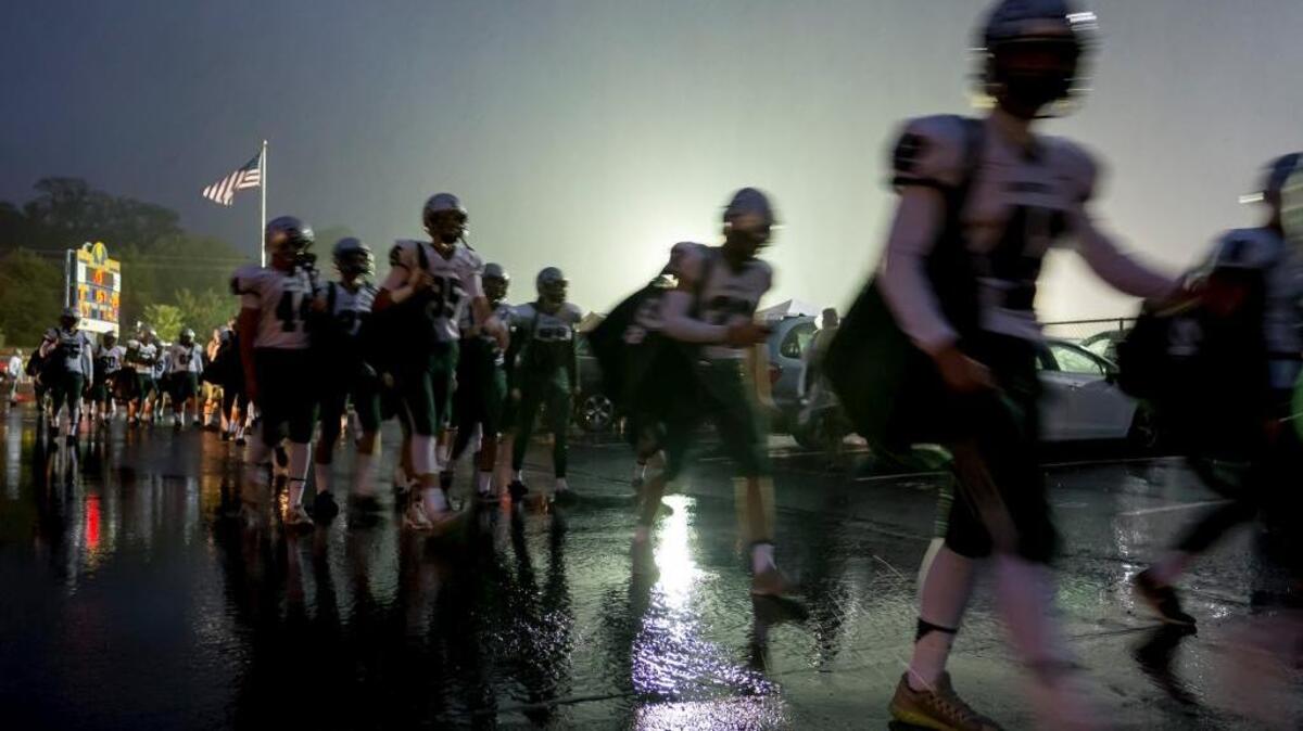 The Granite Bay Grizzlies arrive in the rain before their game against the Oak Ridge Trojans on Friday, Oct. 14, 2016, at Oak Ridge High School.