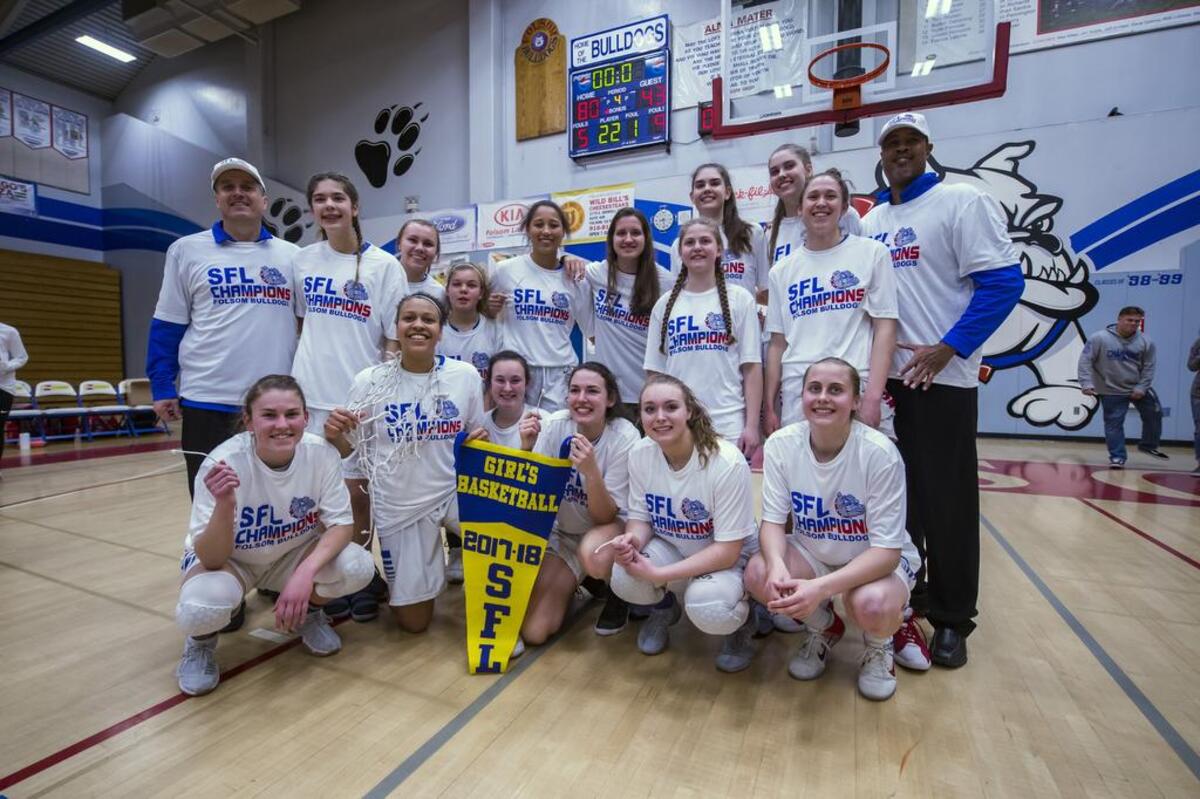 The Folsom Bulldogs Varsity Girls Varsity basketball team celebrates their 80-43 win over the Cosumnes Oaks Wolfpack to win the SFL championship, Tuesday, Feb. 27, 2018.
