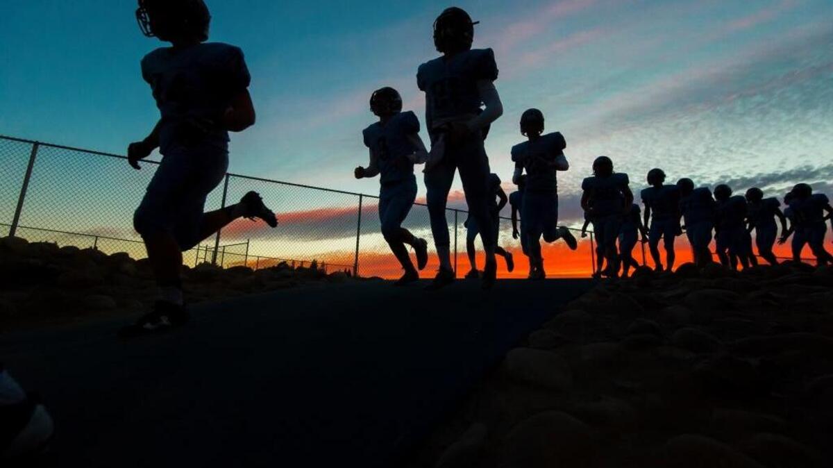 The Oakmont High School football team comes onto the field before Friday night’s game against Antelope.