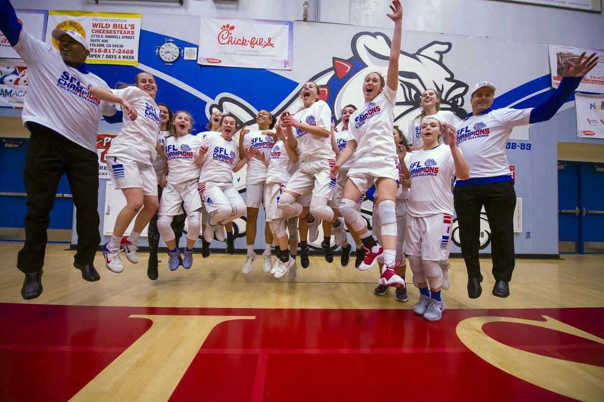 The Folsom Bulldogs Varsity Girls Varsity basketball team celebrates their 80-43 win over the Cosumnes Oaks Wolfpack to win the SFL championship, Tuesday, Feb. 27, 2018.