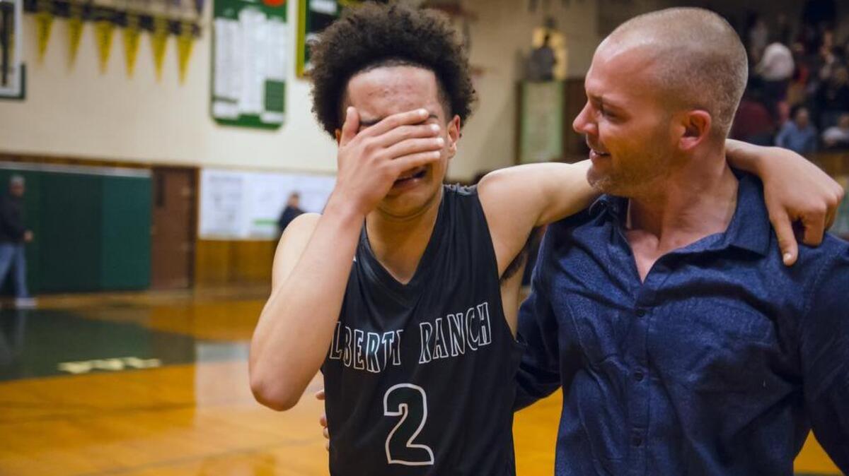 Liberty Ranch's Jalen Patterson (2) reacts as he hugs coach Josh Williams after defeating the Placer Hillman 85-80 in the Division IV CIF Northern California quarterfinal.