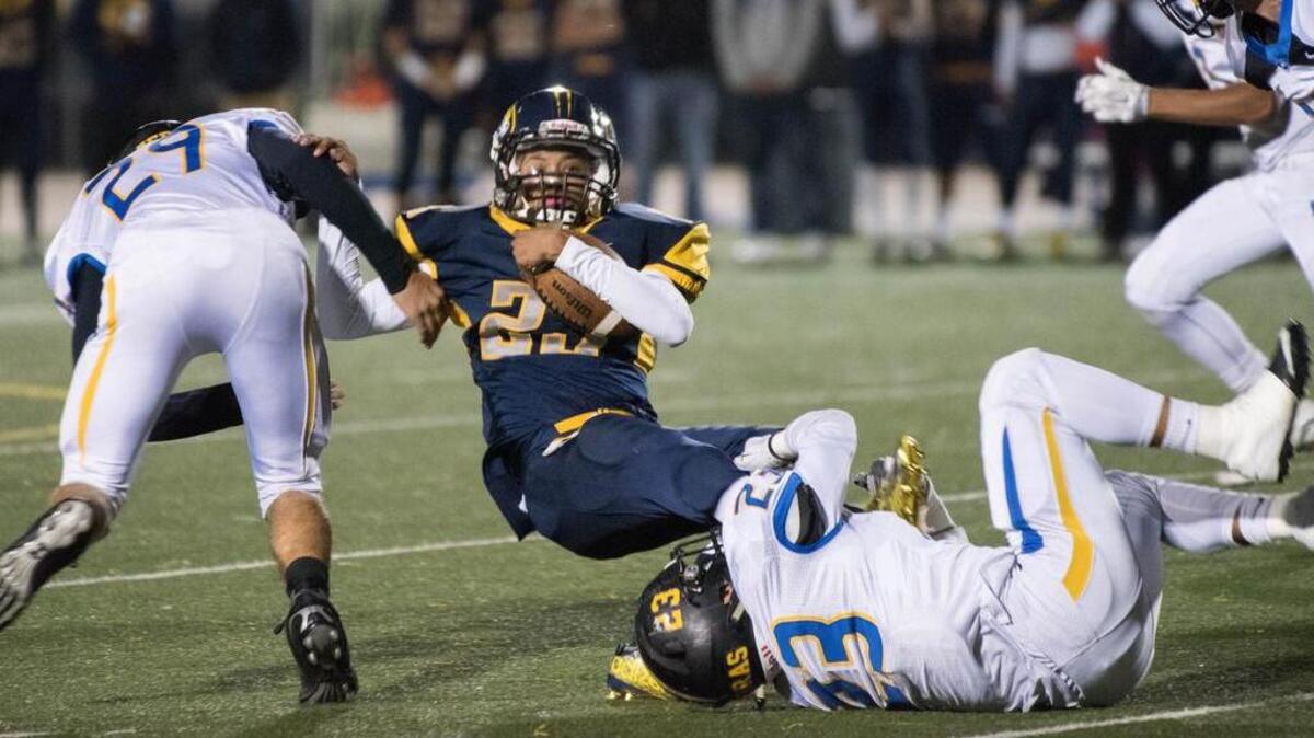 Inderkum Tigers' Jimmie Johnson (23) is brought down by Lincoln Zebras' Brennan Bergman (29) and Alex Benavidez (23) in the first quarter, as the Inderkum Tigers host the Lincoln Fighting Zebras on Friday, November 13, 2015.