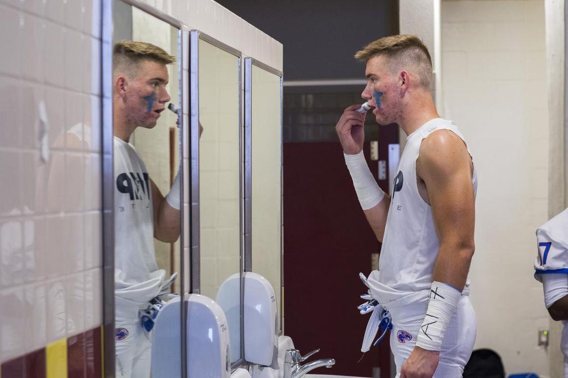 Christian Brothers Falcons Spencer Webb (4) paints his face to get ready inside the locker room before the game.